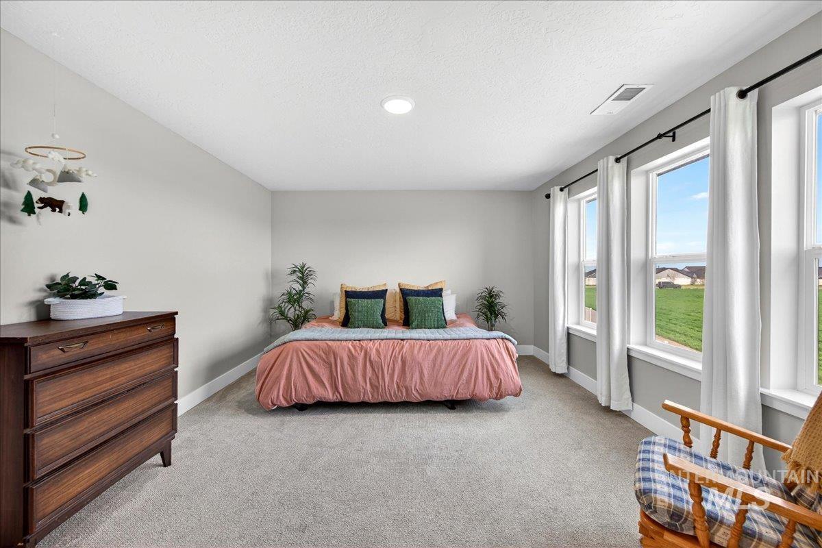 6025 South Catria Place Meridian, ID 83642 - Photo 16 of 34 Bedroom featuring light colored carpet and a textured ceiling