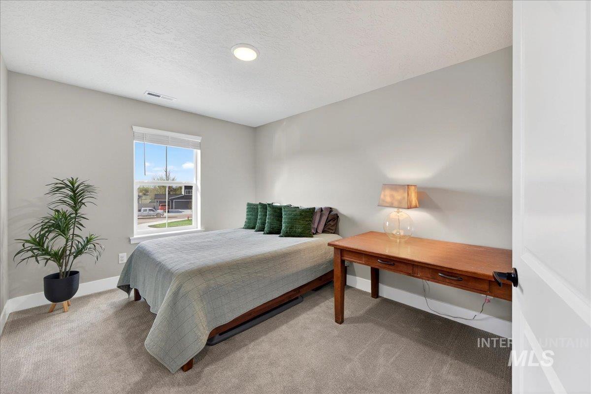 6025 South Catria Place Meridian, ID 83642 - Photo 23 of 34 Bedroom featuring light carpet and a textured ceiling