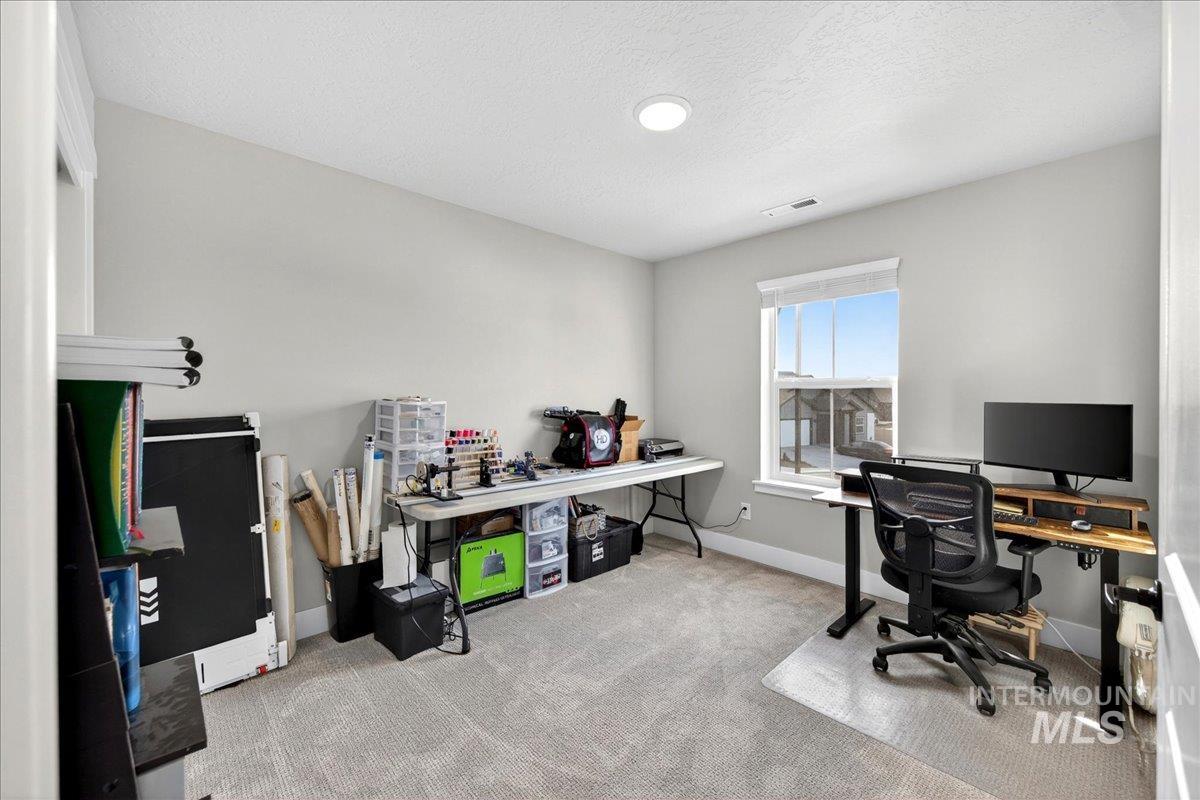 6025 South Catria Place Meridian, ID 83642 - Photo 25 of 34 Home office with light colored carpet and a textured ceiling