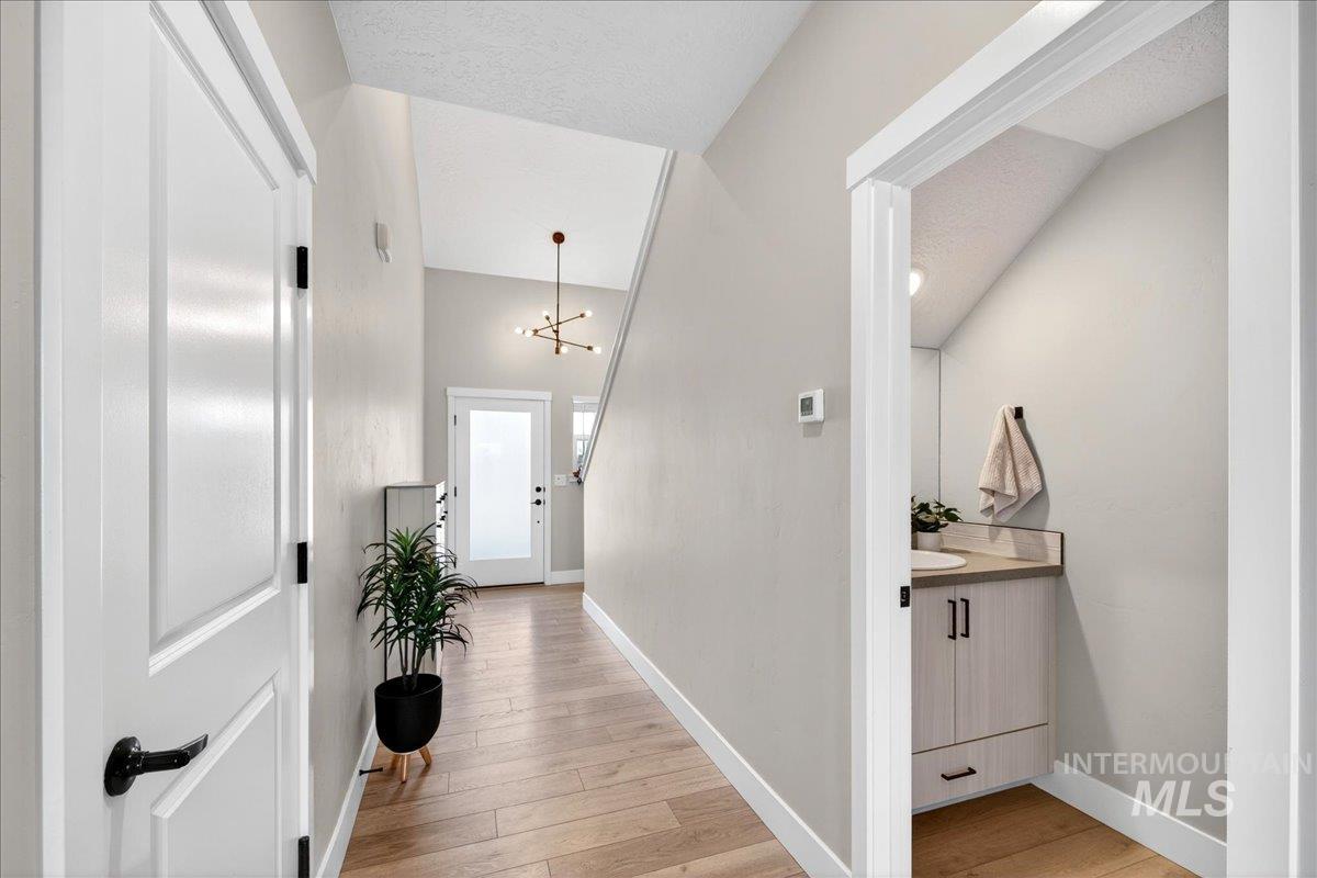 6025 South Catria Place Meridian, ID 83642 - Photo 26 of 34 Hallway with light wood-style floors and hanging lights
