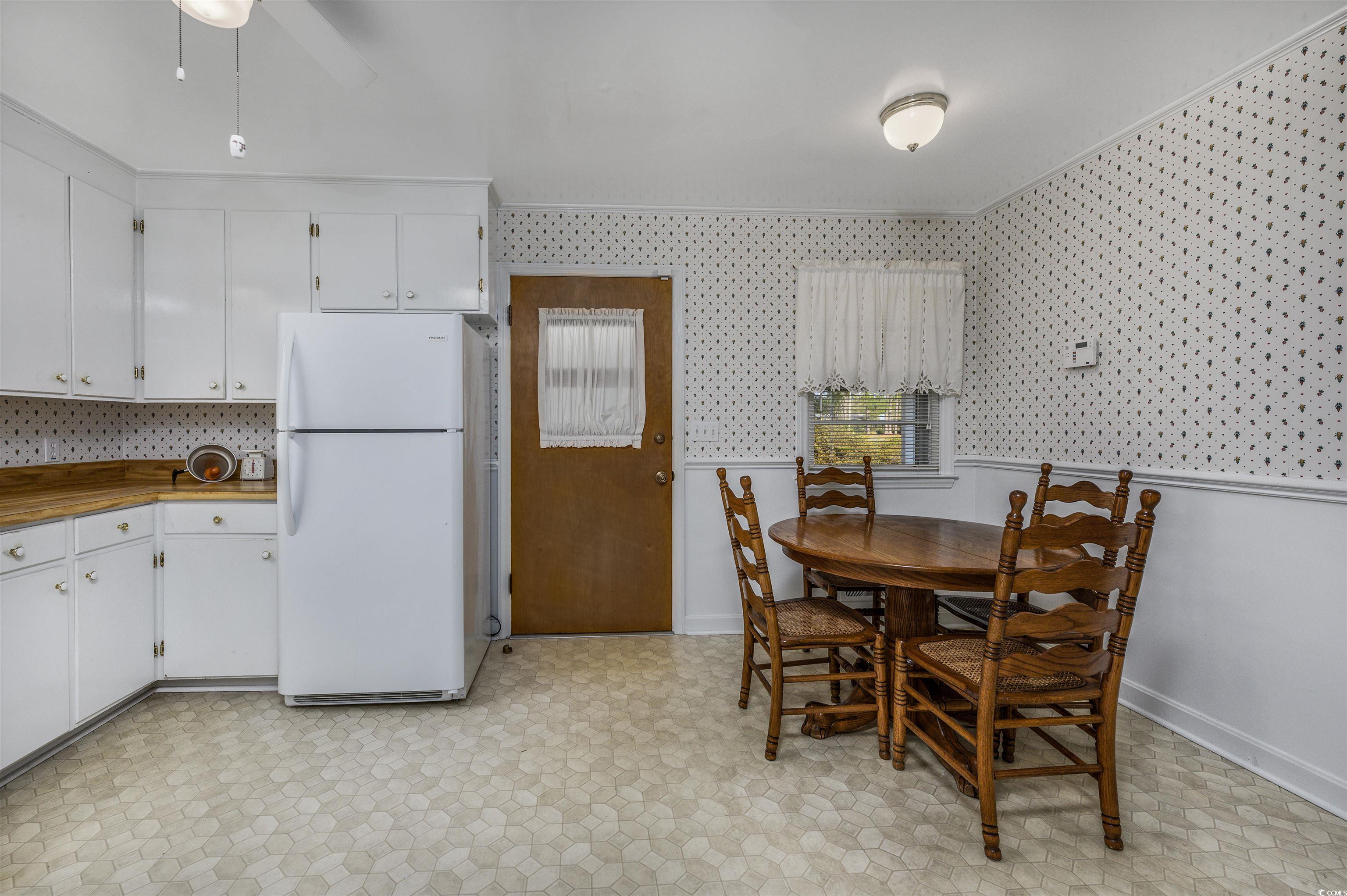 1870 Highway 348 Loris, SC 29569 - Photo 10 of 34 Dining space with light floors, a wainscoted wall, wallpapered walls, and ceiling fan