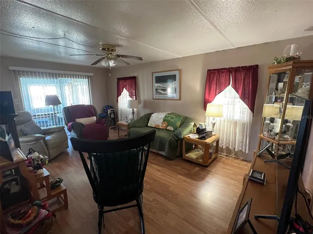a living room with furniture two window and a flat screen tv