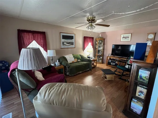 a living room with furniture a flat screen tv and a lamp