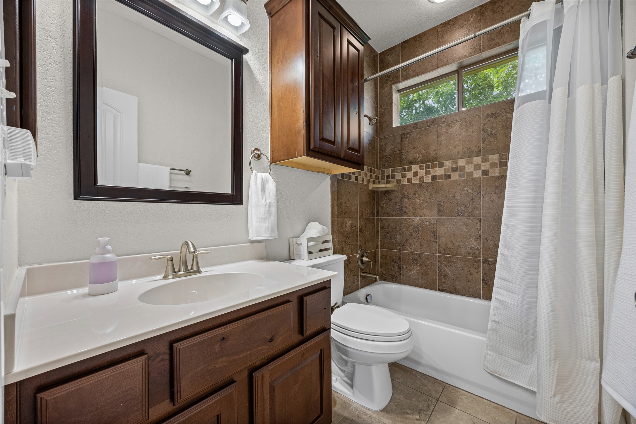 6708 Menchaca Road, Unit 10 Austin, TX 78745 - Photo 25 of 30 The upstairs bathroom with a spacious vanity and tiled shower.