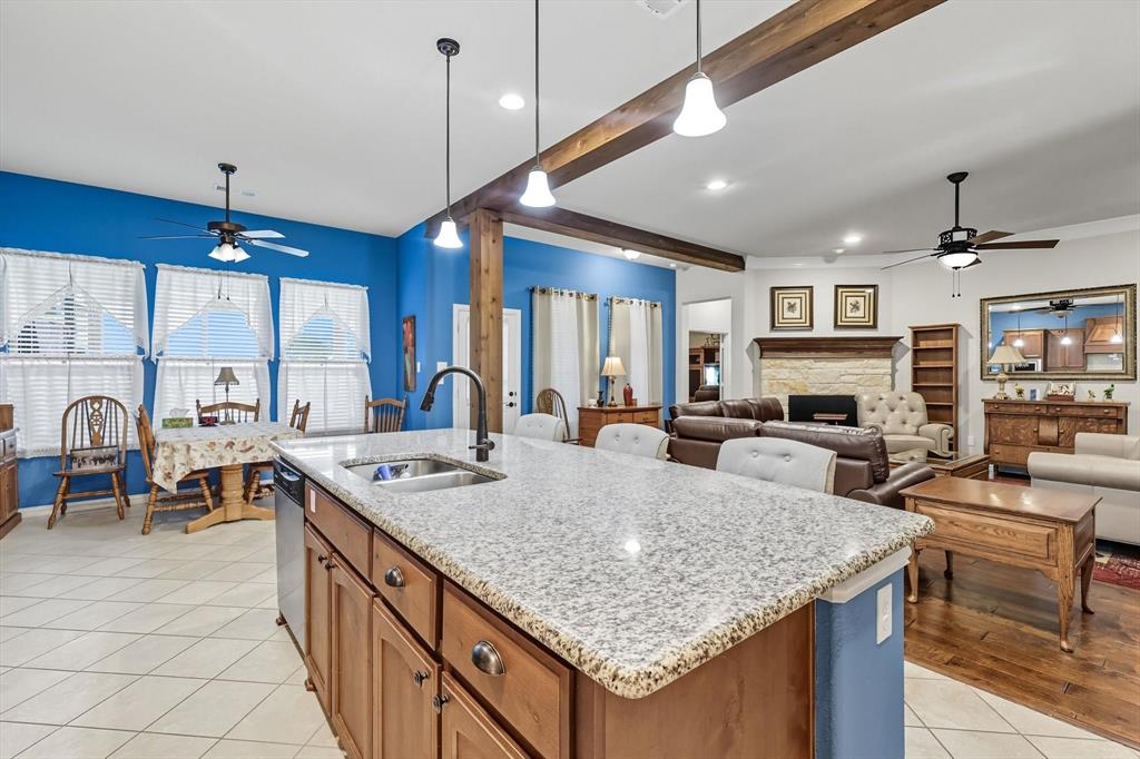 142 High Ridge Court Decatur, TX 76234 - Photo 12 of 40 a large kitchen with kitchen island a stove a sink a dining table and chairs