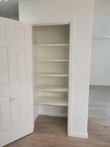 a view of walk in closet with empty racks