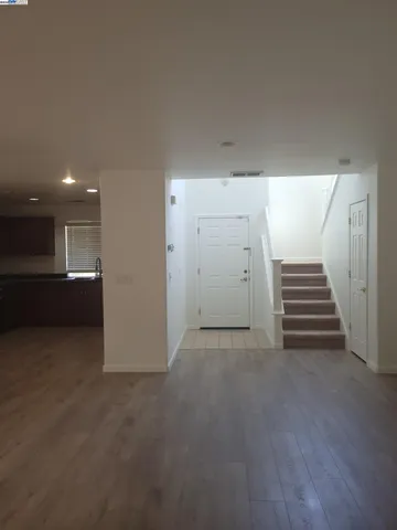 a view of a livingroom with wooden floor and stairs