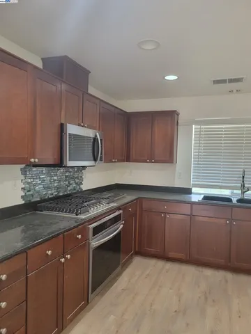 a kitchen with sink a microwave and cabinets
