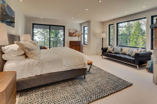 a large bedroom with a bed couch and a large window