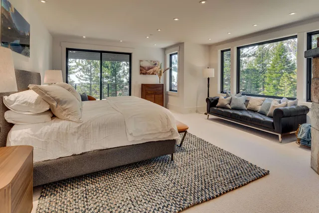 a large bedroom with a bed couch and a large window