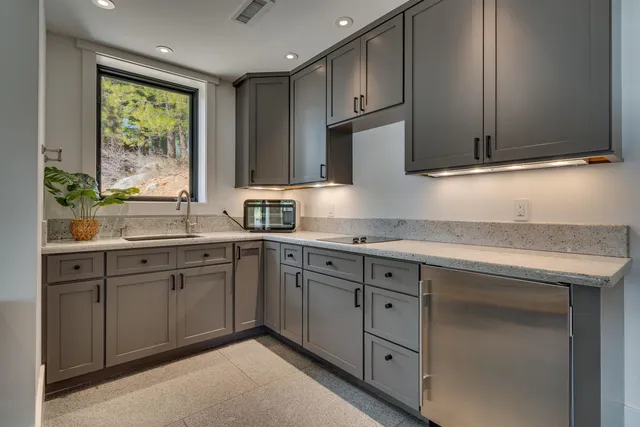 a kitchen with granite countertop cabinets stainless steel appliances a sink and a window