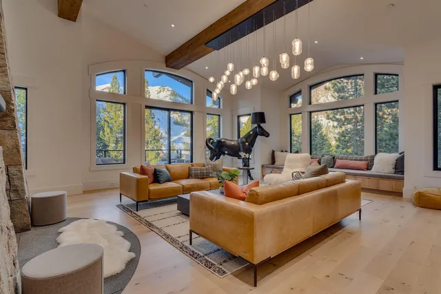 a living room with furniture chandelier and a large window