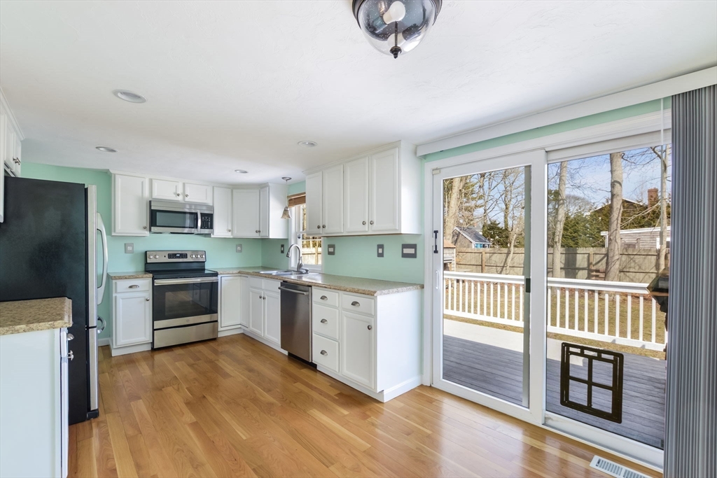 48 Kennedy Circle Barnstable, MA 02601 - Photo 11 of 32 a kitchen with granite countertop a stove a sink and a refrigerator