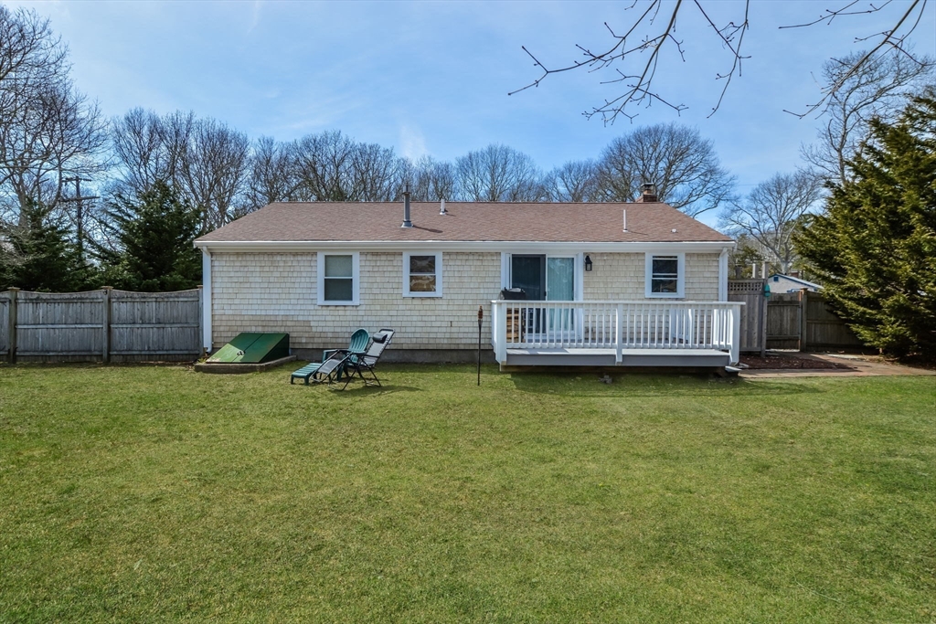 48 Kennedy Circle Barnstable, MA 02601 - Photo 30 of 32 a backyard of a house with barbeque oven and wooden fence