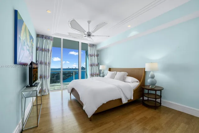 a bedroom with a large bed and a flat tv screen