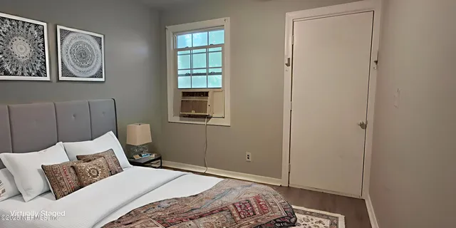 a bedroom with a bed and painting on the wall