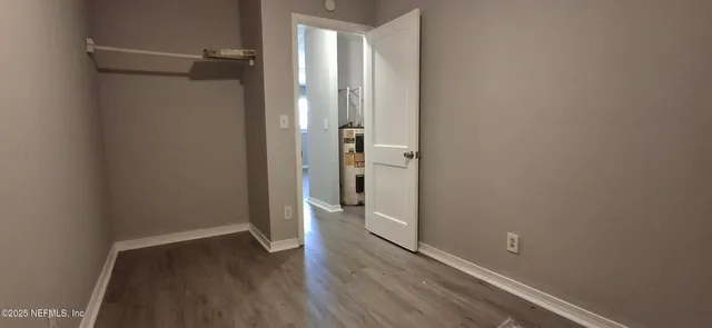a view of a room with wooden floor