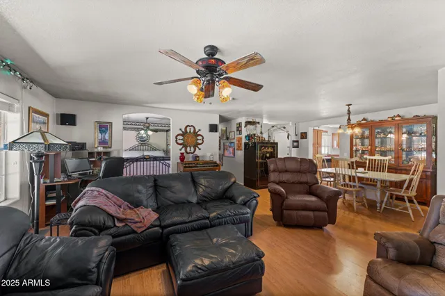 a living room with furniture a ceiling fan and a window