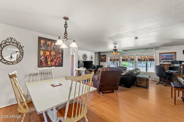 a living room with furniture a dining table and a chandelier