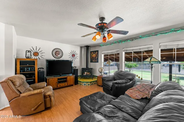 a living room with furniture a floor to ceiling window and a flat screen tv