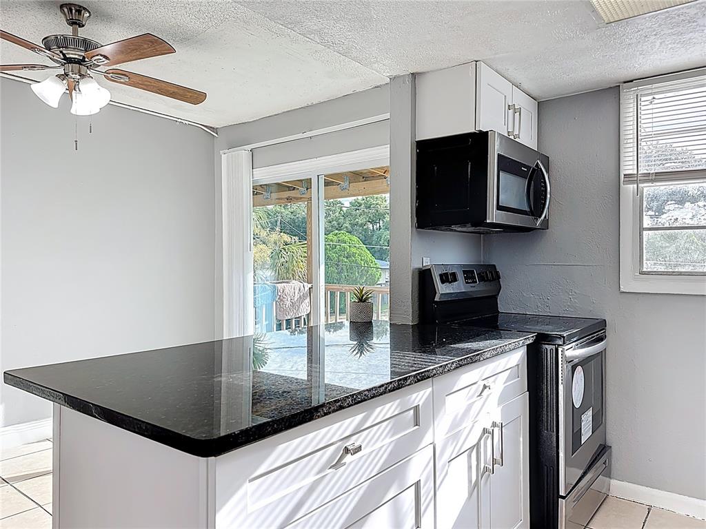 2753 L B McLeod Road, Unit D Orlando, FL 32805 - Photo 17 of 48 a kitchen with stainless steel appliances granite countertop a sink a stove top oven a counter space and cabinets