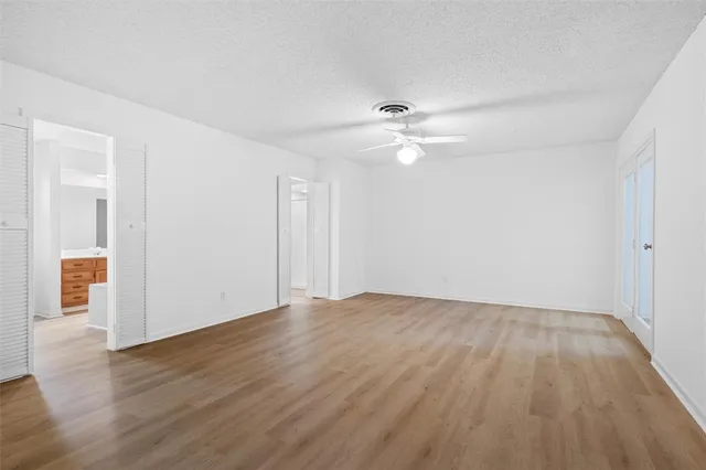 a view of an empty room with wooden floor