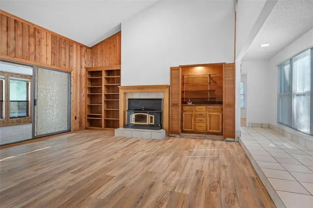 a view of empty room with wooden floor and fireplace