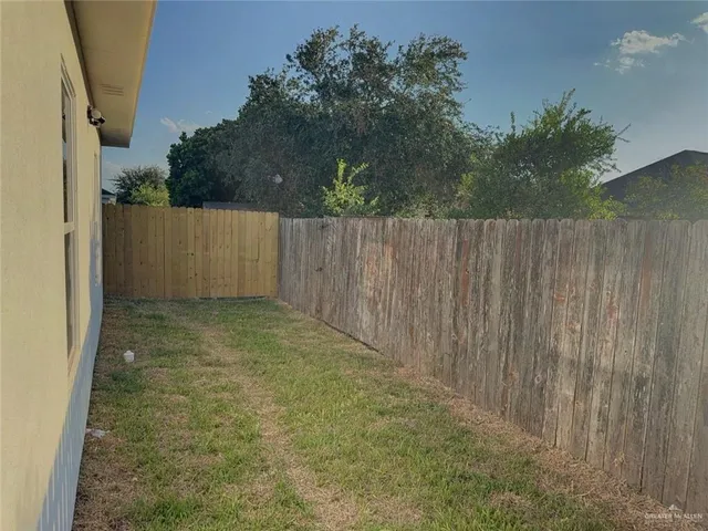 a view of a backyard with wooden fence