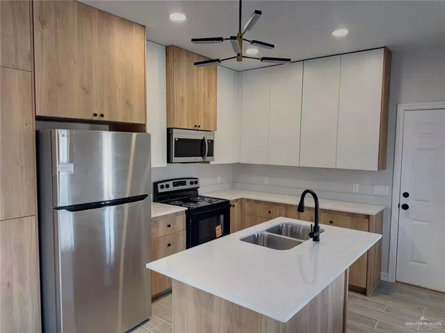 a kitchen with kitchen island a sink stainless steel appliances and refrigerator