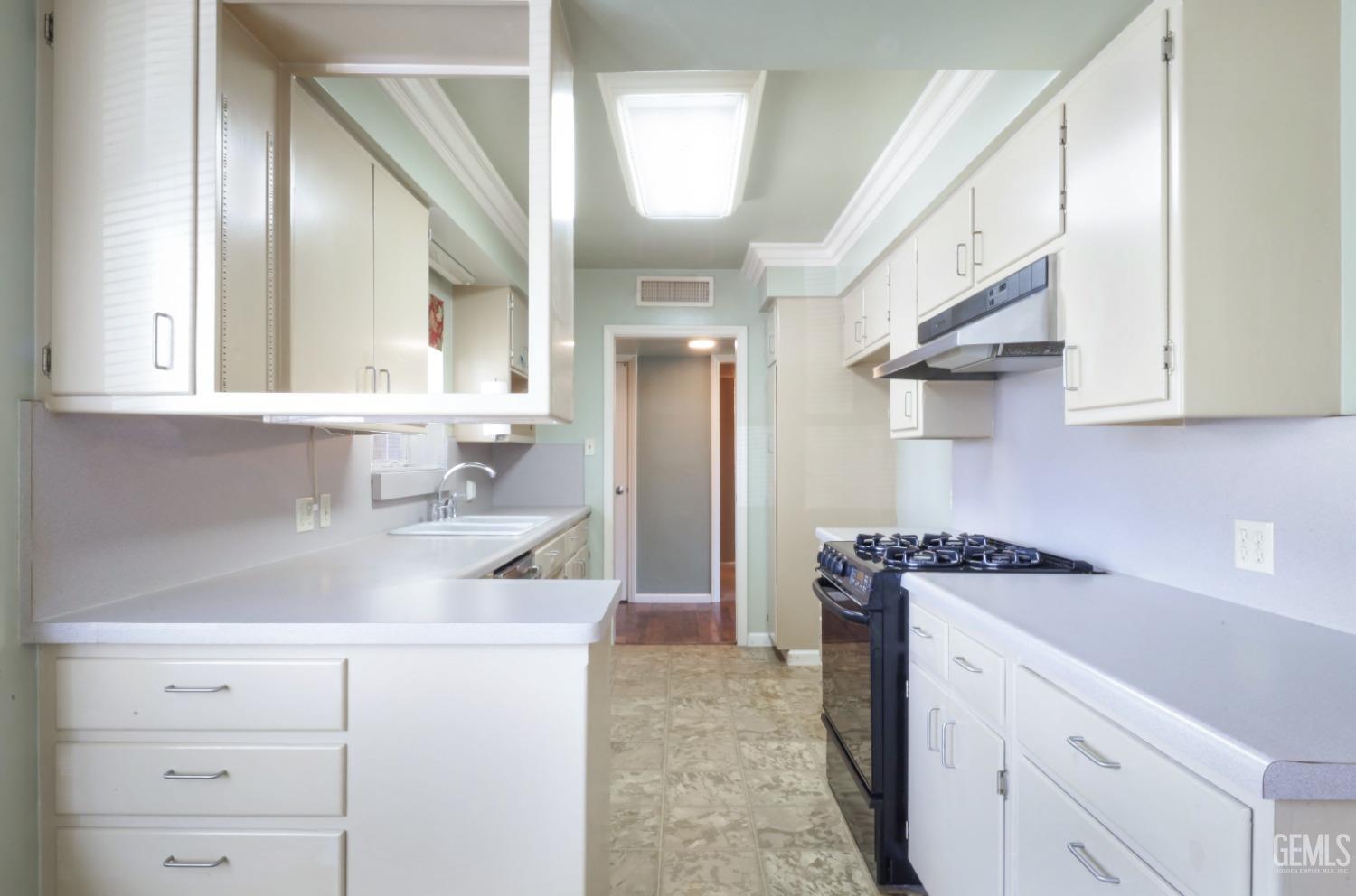 Undisclosed Address Bakersfield, CA 93305 - Photo 12 of 33 a kitchen with a sink dishwasher a stove and a refrigerator with wooden cabinets
