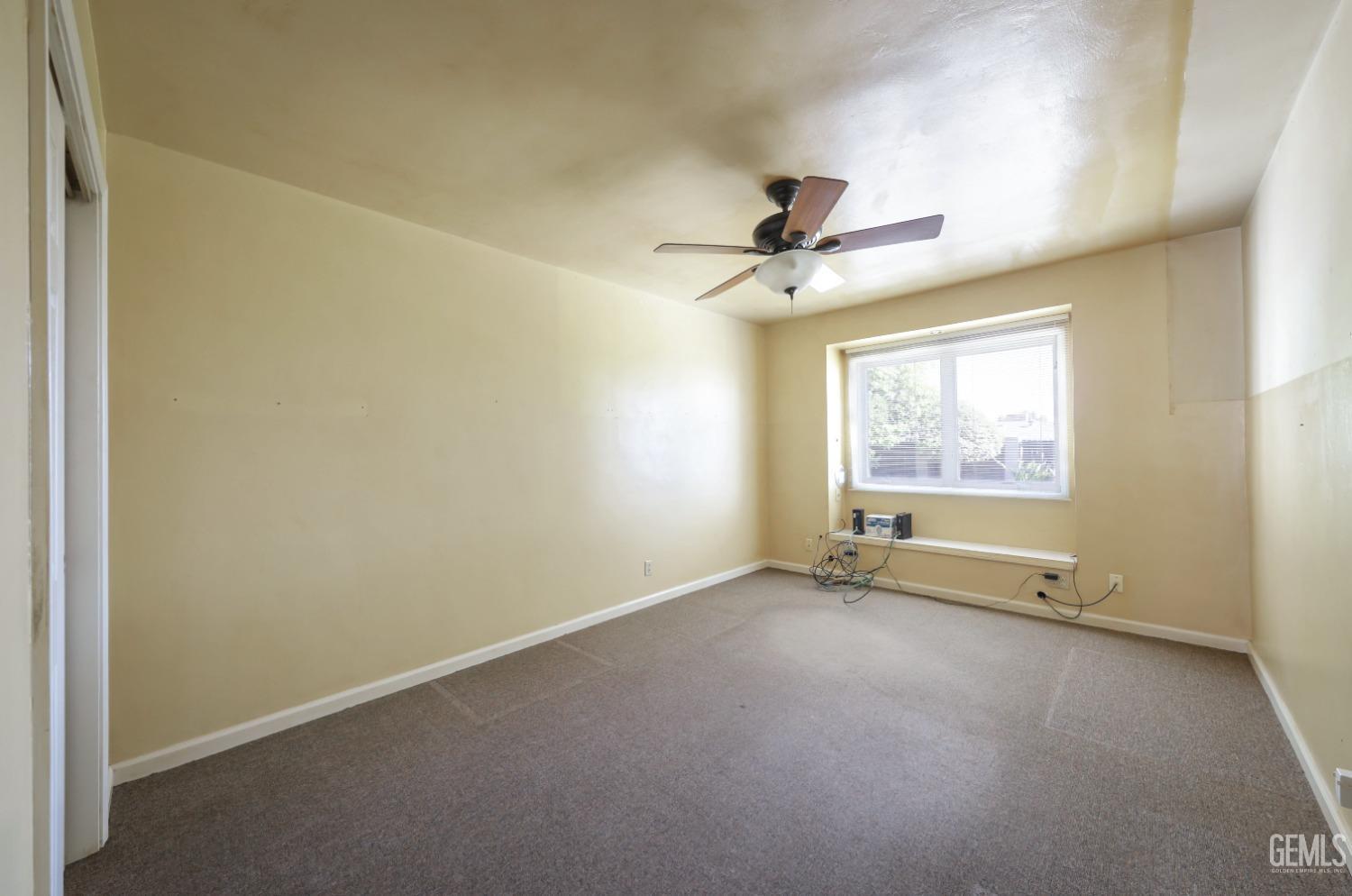 Undisclosed Address Bakersfield, CA 93305 - Photo 15 of 33 an empty room with windows and fan