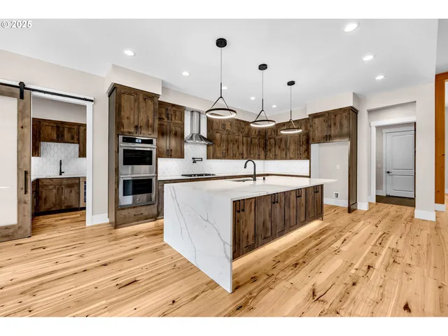 a kitchen with stainless steel appliances kitchen island a sink refrigerator and cabinets