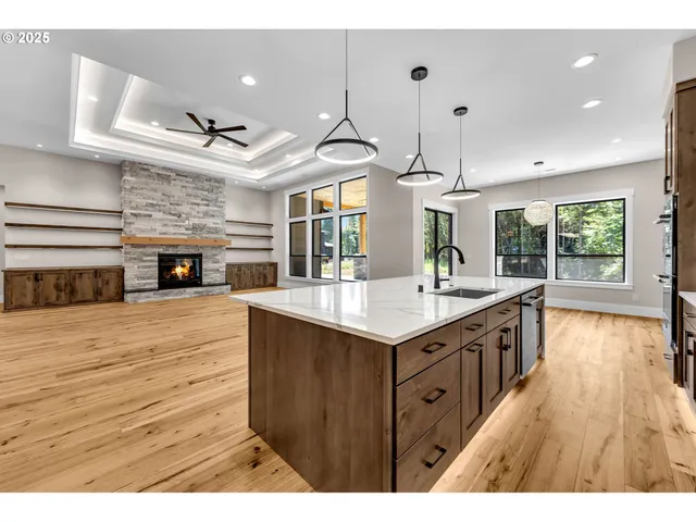 a kitchen with stainless steel appliances granite countertop a sink a stove and a wooden floors