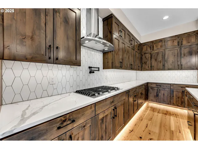 a kitchen with granite countertop a stove a sink dishwasher and cabinets with wooden floor