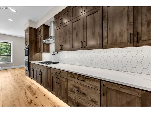 a kitchen with stainless steel appliances wooden cabinets a sink and a stove