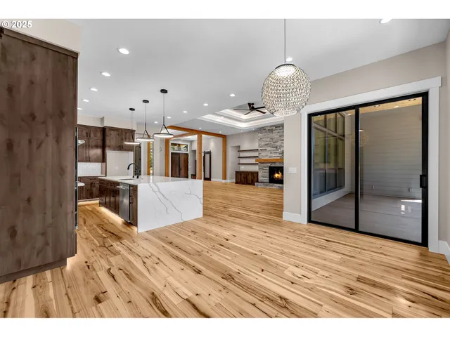 a large room with kitchen view and wooden floor