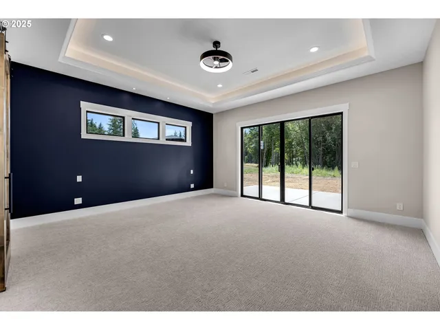 a view of an empty room with a ceiling fan and window