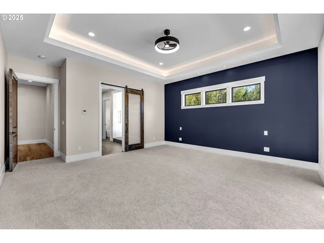 a view of an empty room with windows and a ceiling fan