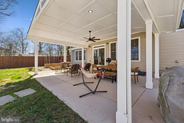a view of a patio with dining table and chairs with a small yard