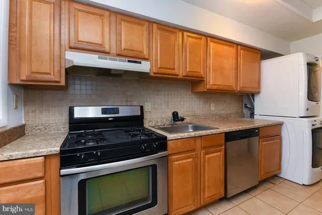 a kitchen with stainless steel appliances granite countertop wooden cabinets granite counter tops and a stove