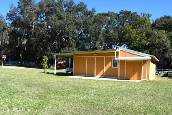 a view of swimming pool with lawn chairs and wooden fence