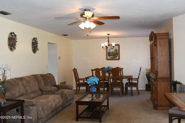 a living room with furniture a chandelier and a flat screen tv