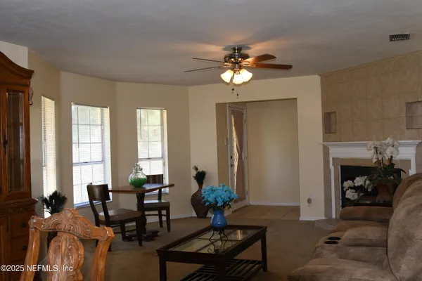 a living room with furniture a fireplace and a chandelier