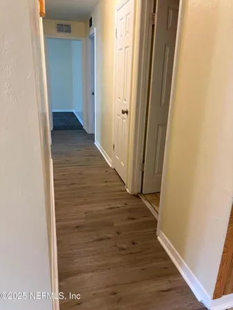 a view of a hallway with wooden floor