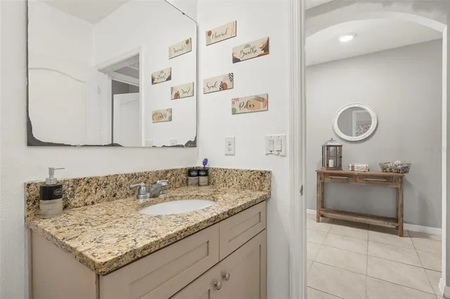 a bathroom with a granite countertop sink a mirror and shower