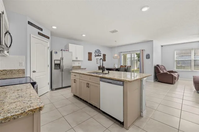 a kitchen with stainless steel appliances granite countertop a sink and a refrigerator