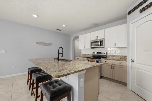 a kitchen with a sink a stove and cabinets
