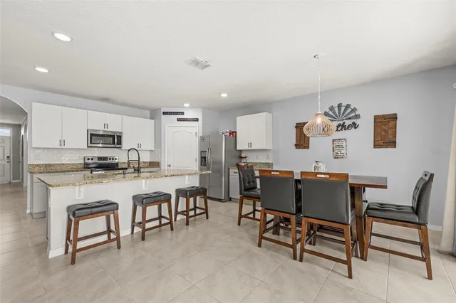 a living room with furniture a dining table and kitchen view