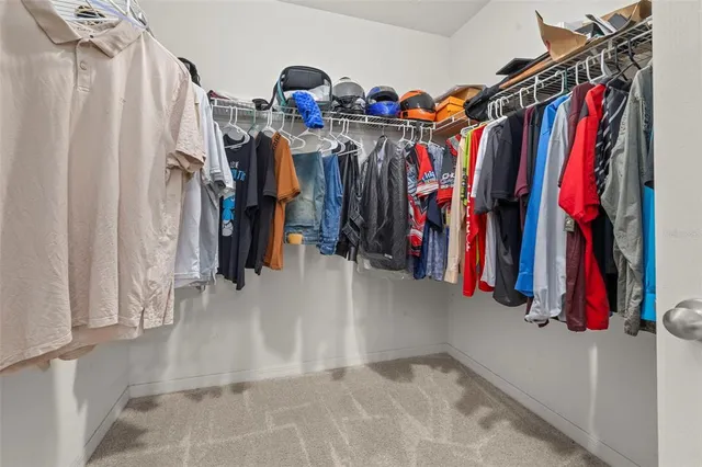 a view of walk in closet with clothes