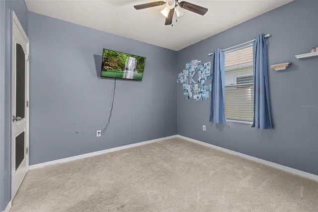a view of a livingroom with a ceiling fan and window